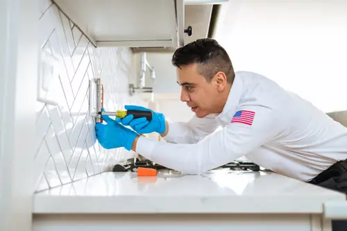 Closeup of Mister Sparky Electrician Tech installing an outline in an Ocala Florida home's kitchen